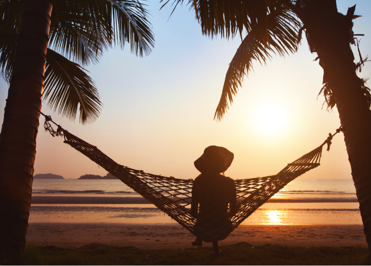 image of silhouette of woman on hammock looking out to the sea on beach