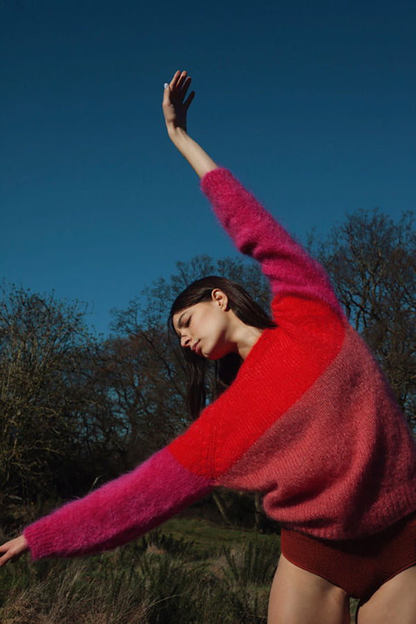 model wearing red and pink jumper with no trousers