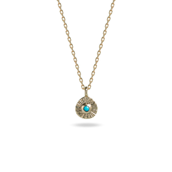 small gold pendant with turquoise stone and stamped line detail on gold chain at IndependentBoutique.com