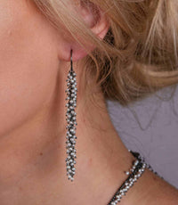 pearl and oxidised silver catkin earrings on a model.