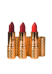 three gold lipsticks in dark red, red and coral in gold tubes from Fatale cosmetics