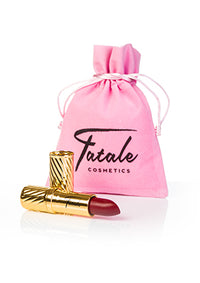 red lipstick in gold embossed tube with pink velvet bag at IndependentBoutique.com